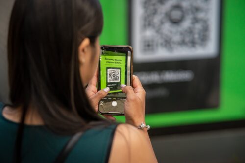 mujer con telefono en mano escaneando codigo qr